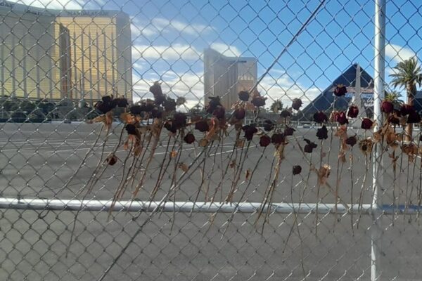 C Julien Winkel. Quelques roses desséchées sont accrochées à l'entrée du site de la tragédie. Au loin, à gauche, on distingue la silhouette du Mandalay Bay.