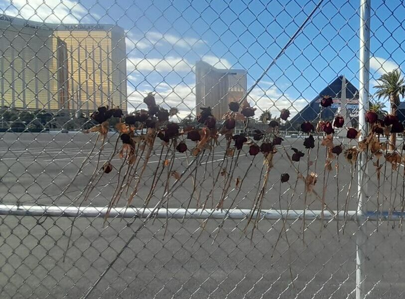 C Julien Winkel. Quelques roses desséchées sont accrochées à l'entrée du site de la tragédie. Au loin, à gauche, on distingue la silhouette du Mandalay Bay.